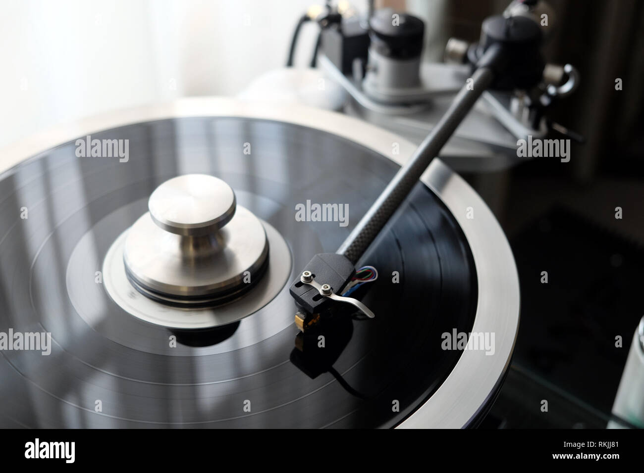 Graphite tonearm of vintage turntable with LP record close up view Stock Photo