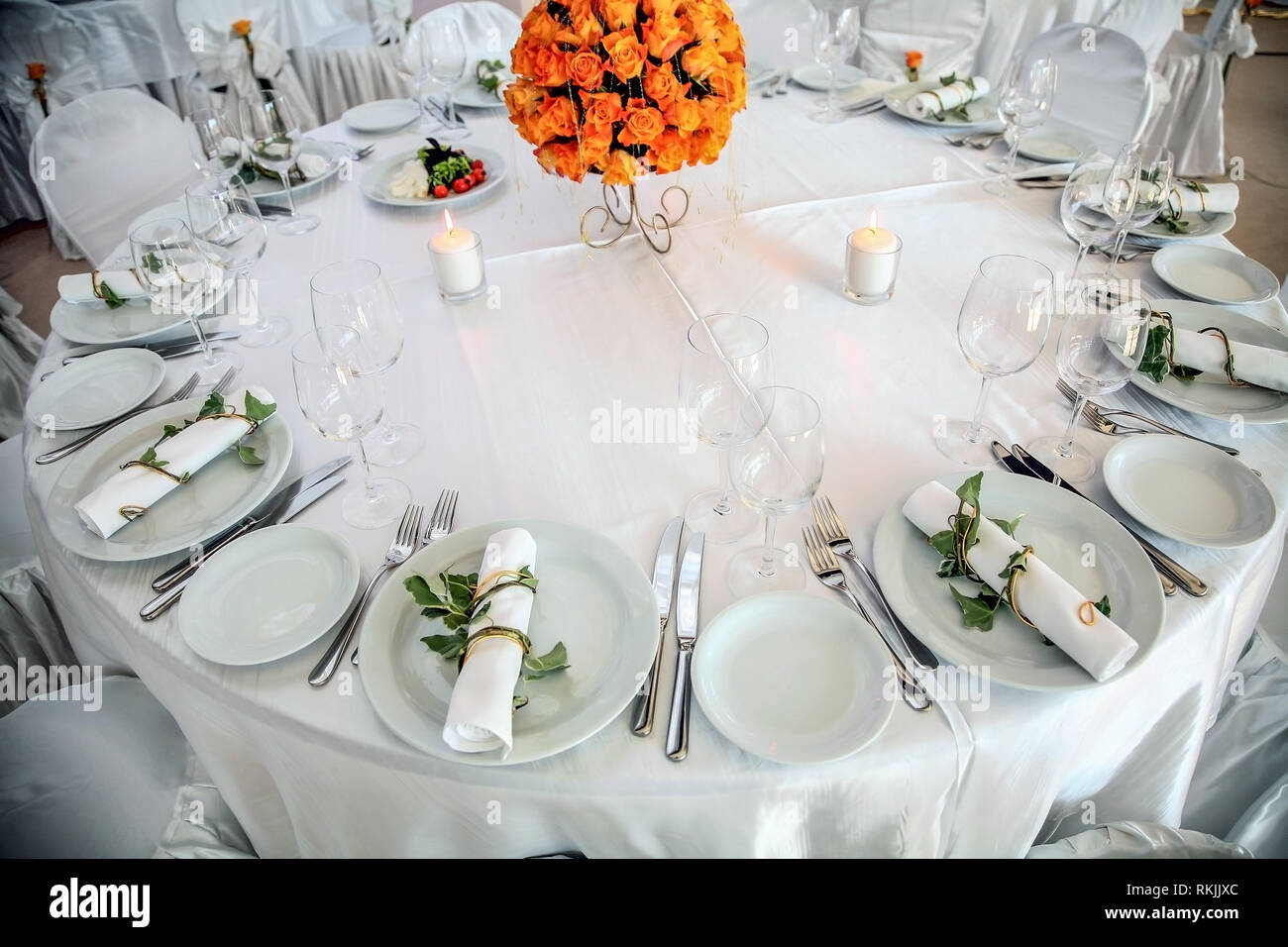 Holiday table setting decorated with flowers and candles. Stock Photo