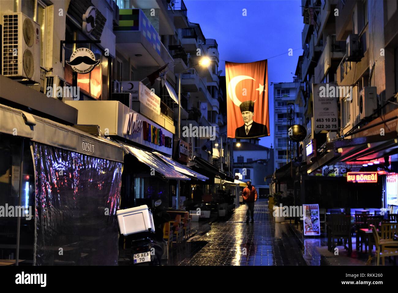 Izmir, Turkey. 21st Jan, 2019. A man walks under a Turkish flag picturing Mustafa Kemal Ataturk