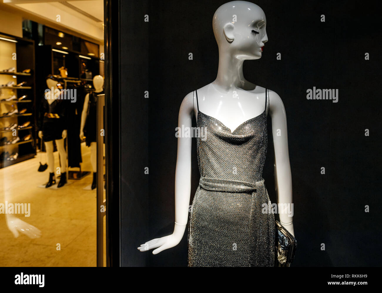 Luxury female evening dress on mannequin seen from the shopping street