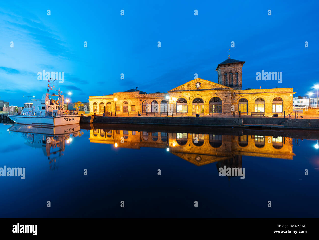 Night view of Illuminated Forth Ports building reflected in dock at night in Leith, Edinburgh, Scotland, UK Stock Photo