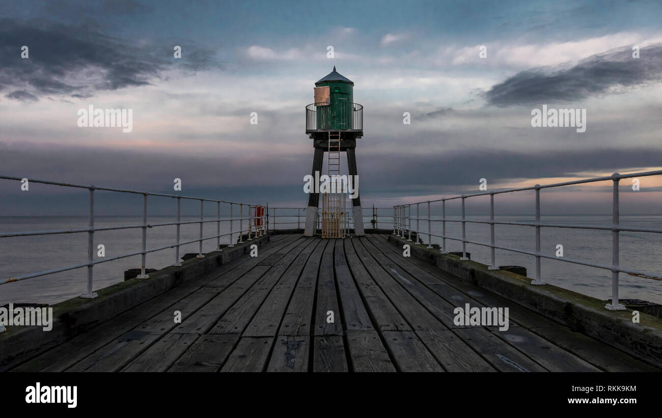 Whitby Abbey pier with lighthouse in the end. Seaside with beautiful