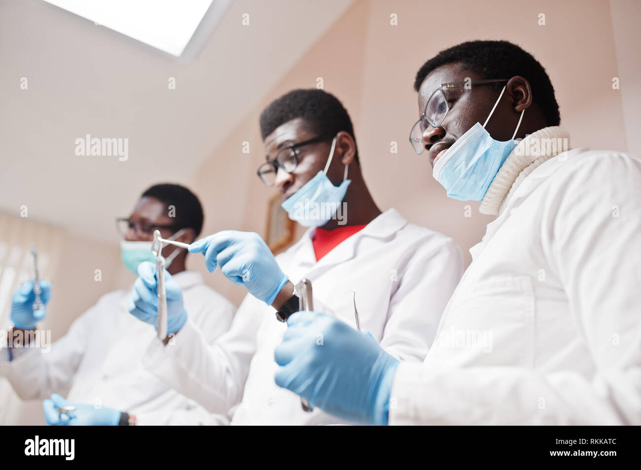 Close uo of three african american male doctors colleagues with tools at hands in clinic. Stock Photo