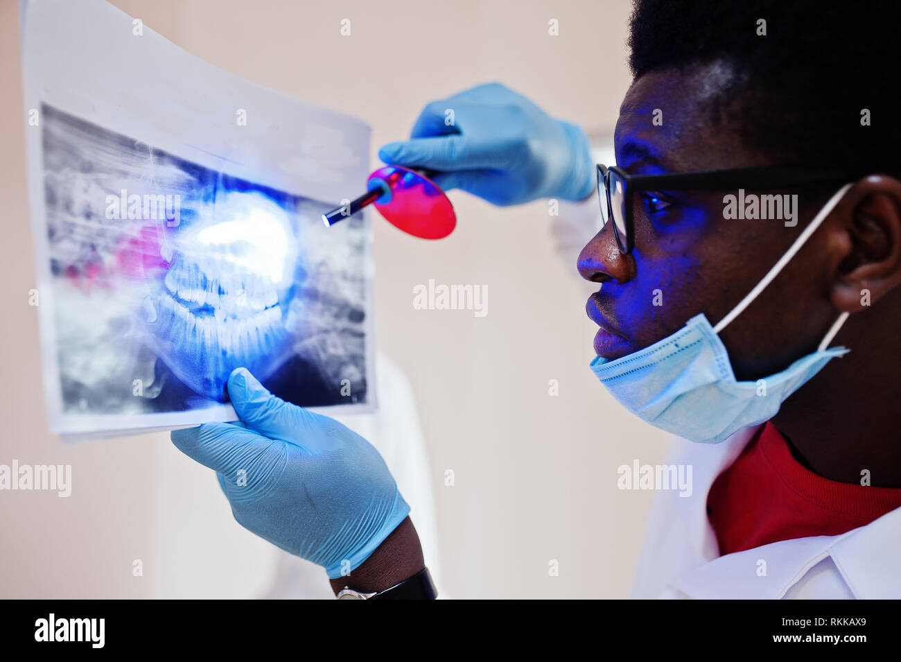Dentist office and doctor practice concept. Close uo of hands professional african american doctor at dentistry medical pointing on teeth X-ray. Stock Photo
