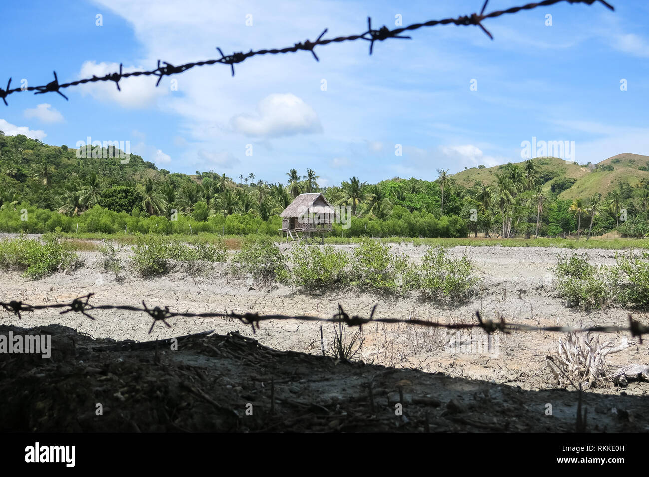 Barbed Wire fence rustic village hut in hilly Philippine field