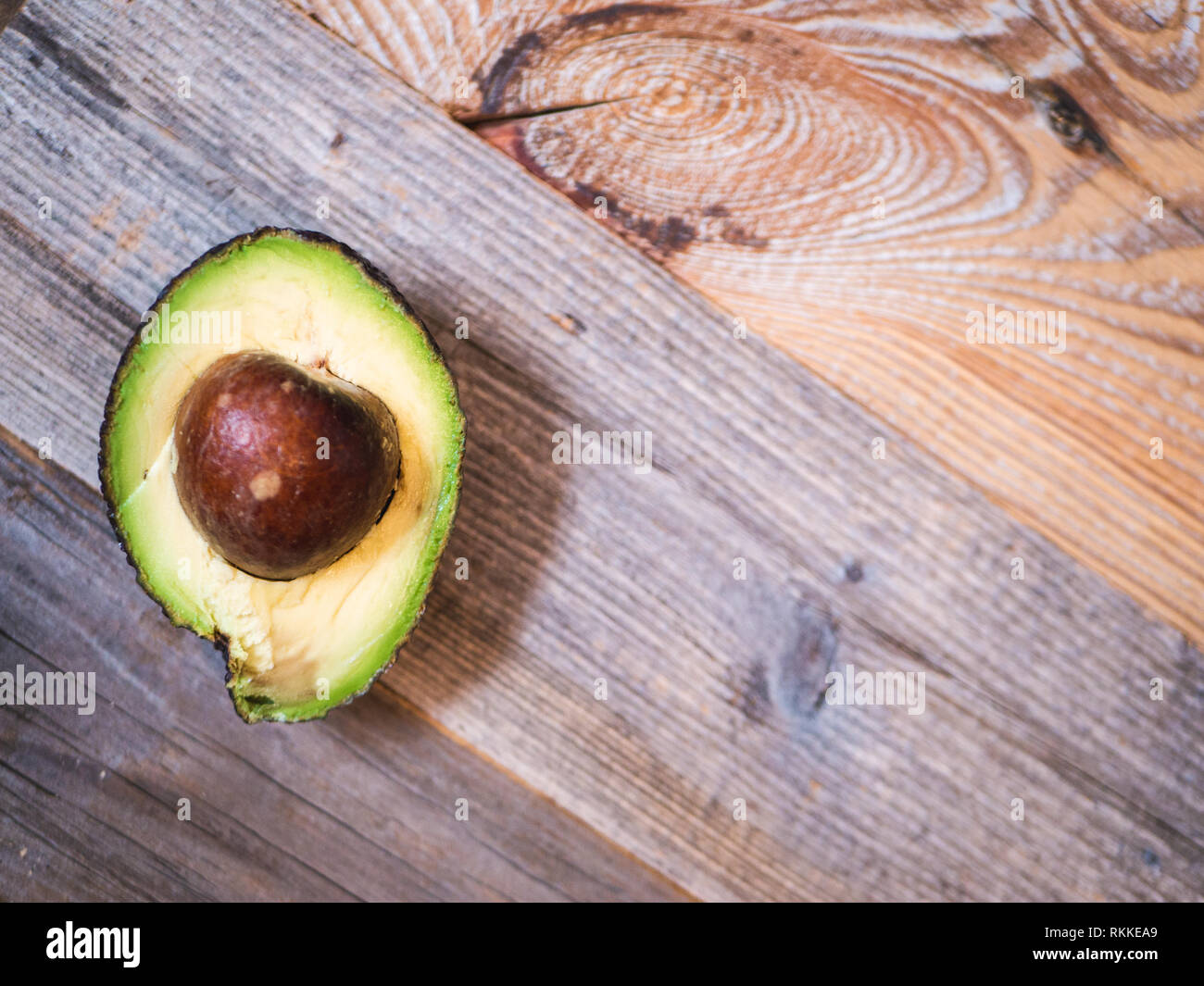 Top view of an avocado half on a wooden board Stock Photo - Alamy