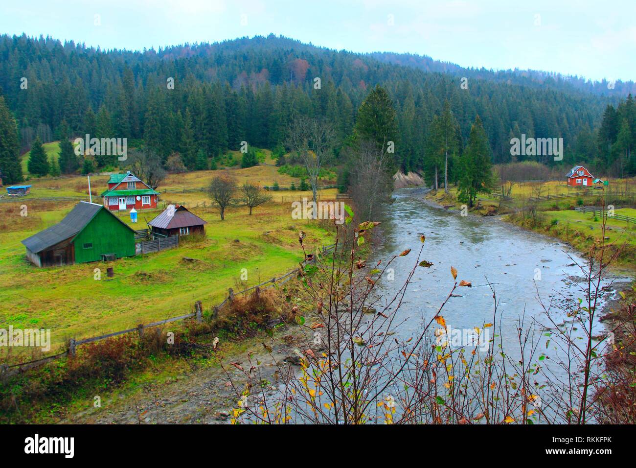 landscape with mountainous river flowing in Ukrainian village in forest of Carpathian mountains. Stock Photo