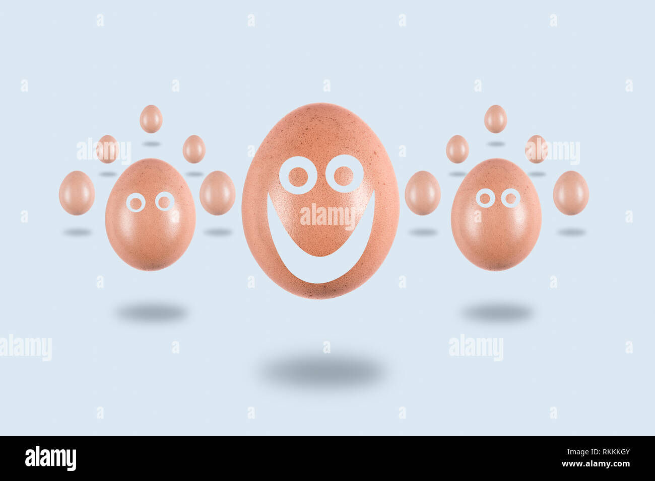 Levitating eggs  with funny painted faces on a light background, conceptual Easter postcard Stock Photo