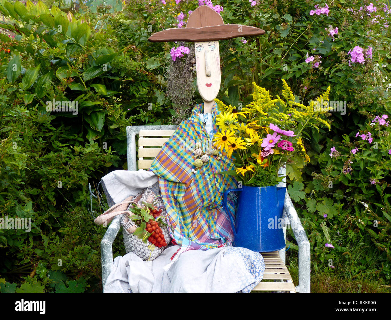 Garden statue and scarecrow dressed up with a bountiful fresh harvest from the community garden, Maine, USA Stock Photo