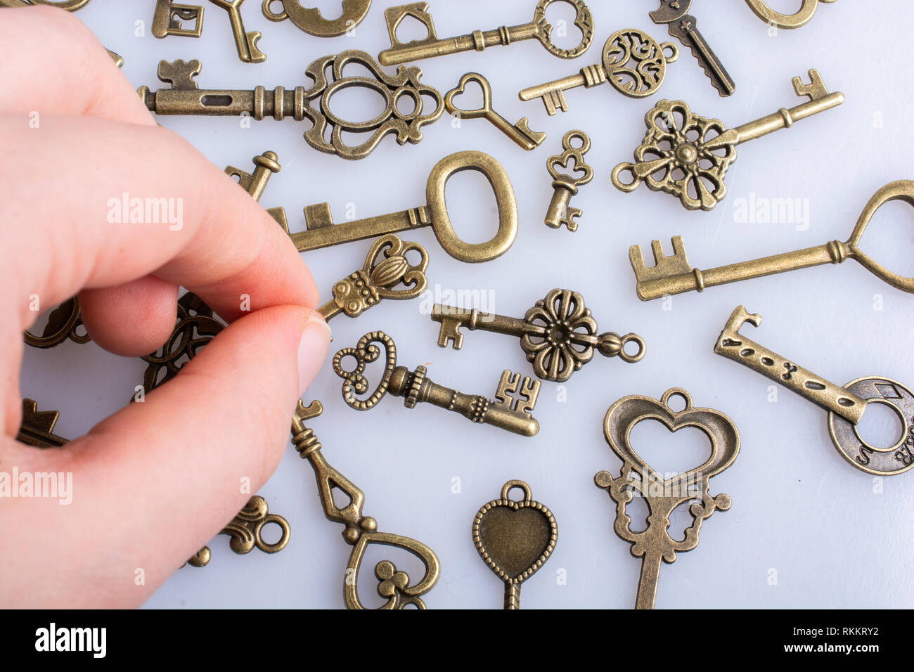 Hand and retro style metal keys on a white background Stock Photo - Alamy