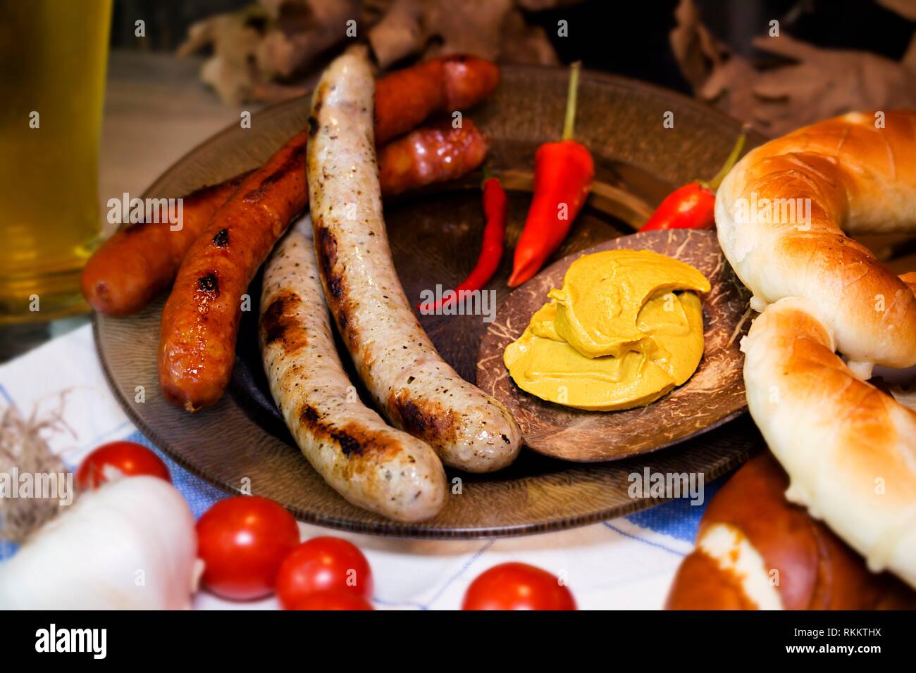 Bavarian White And Red Sausages With Mustard, Bavarian Buns and Pretzels At The Table. October Fest Concept. Stock Photo