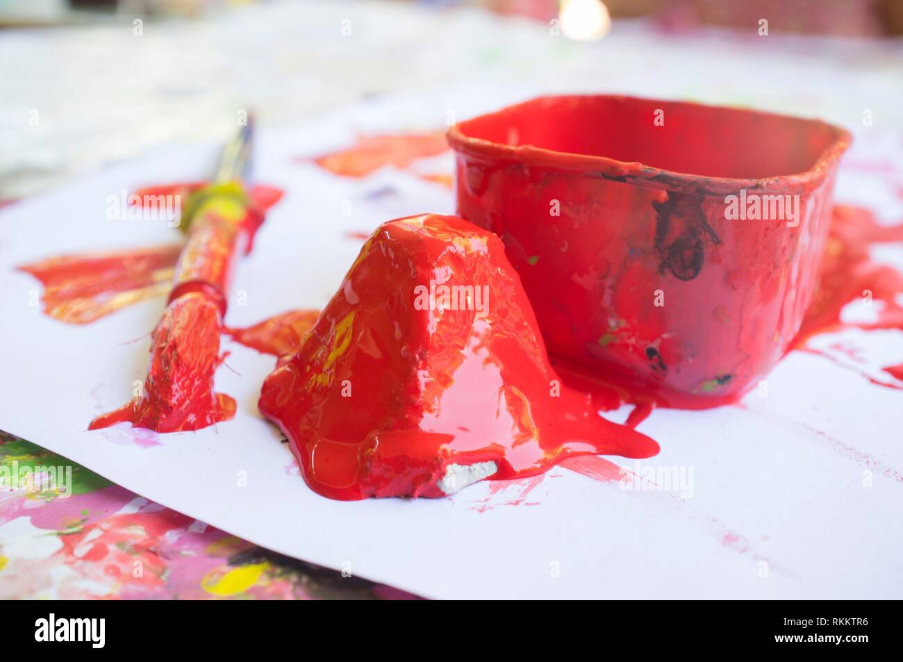 Red paint and paint brush at manual arts workshop for children. Closeup. Stock Photo