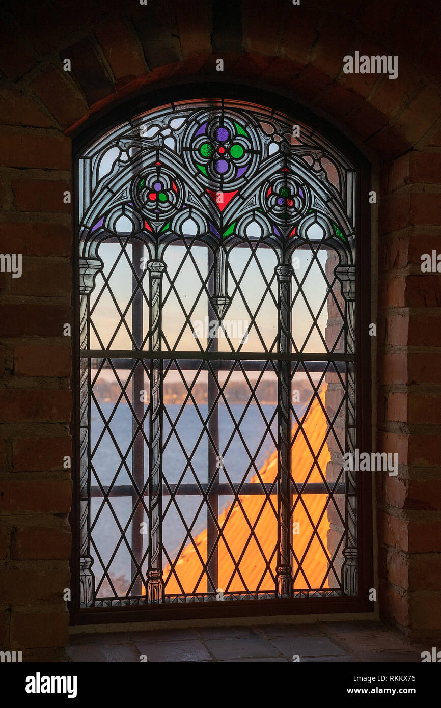 Window with stained glass from Trakai Island Castle chapel to the lake sunny autumn day Stock Photo