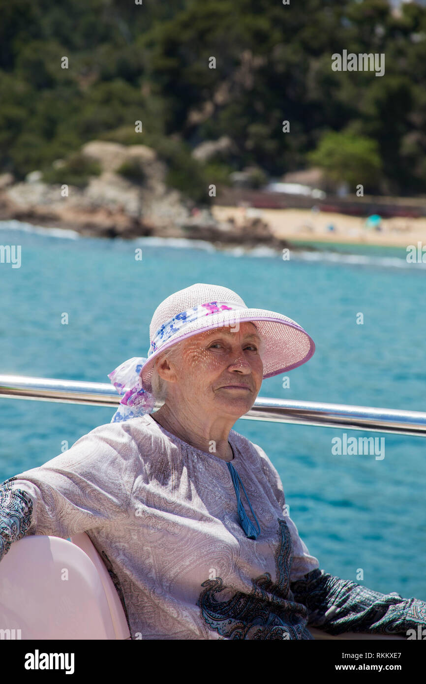 Senior woman enjoys summer vacation in a sea voyage on a pleasure boat. Stock Photo