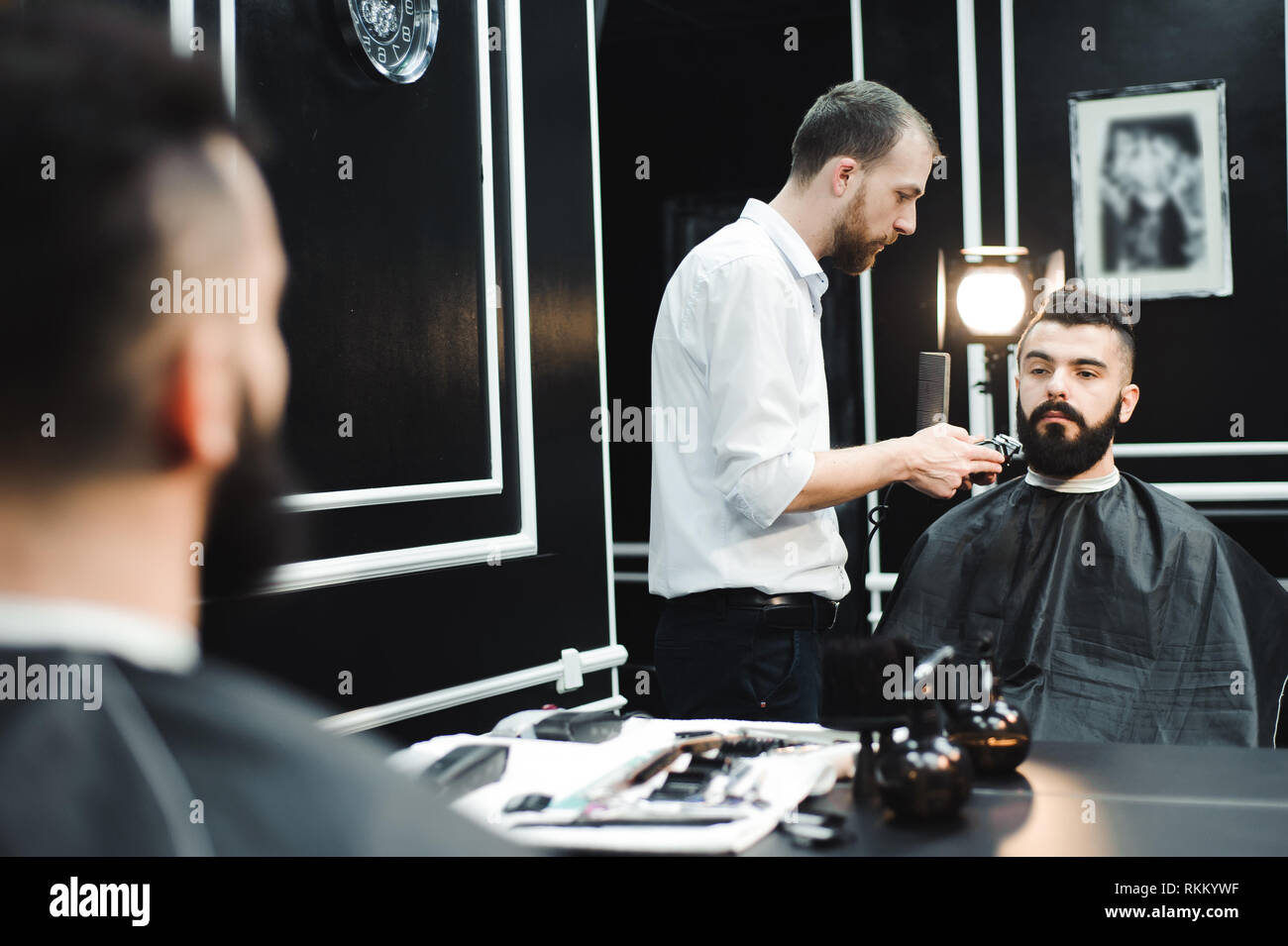 Master cuts hair and beard of men in the barbershop, hairdresser Stock ...