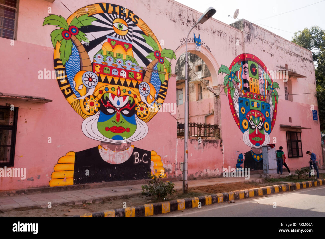 Group of young men filming in front of large street mural by Indian artist Harsh Raman, in Lodhi Colony, New Delhi, India Stock Photo