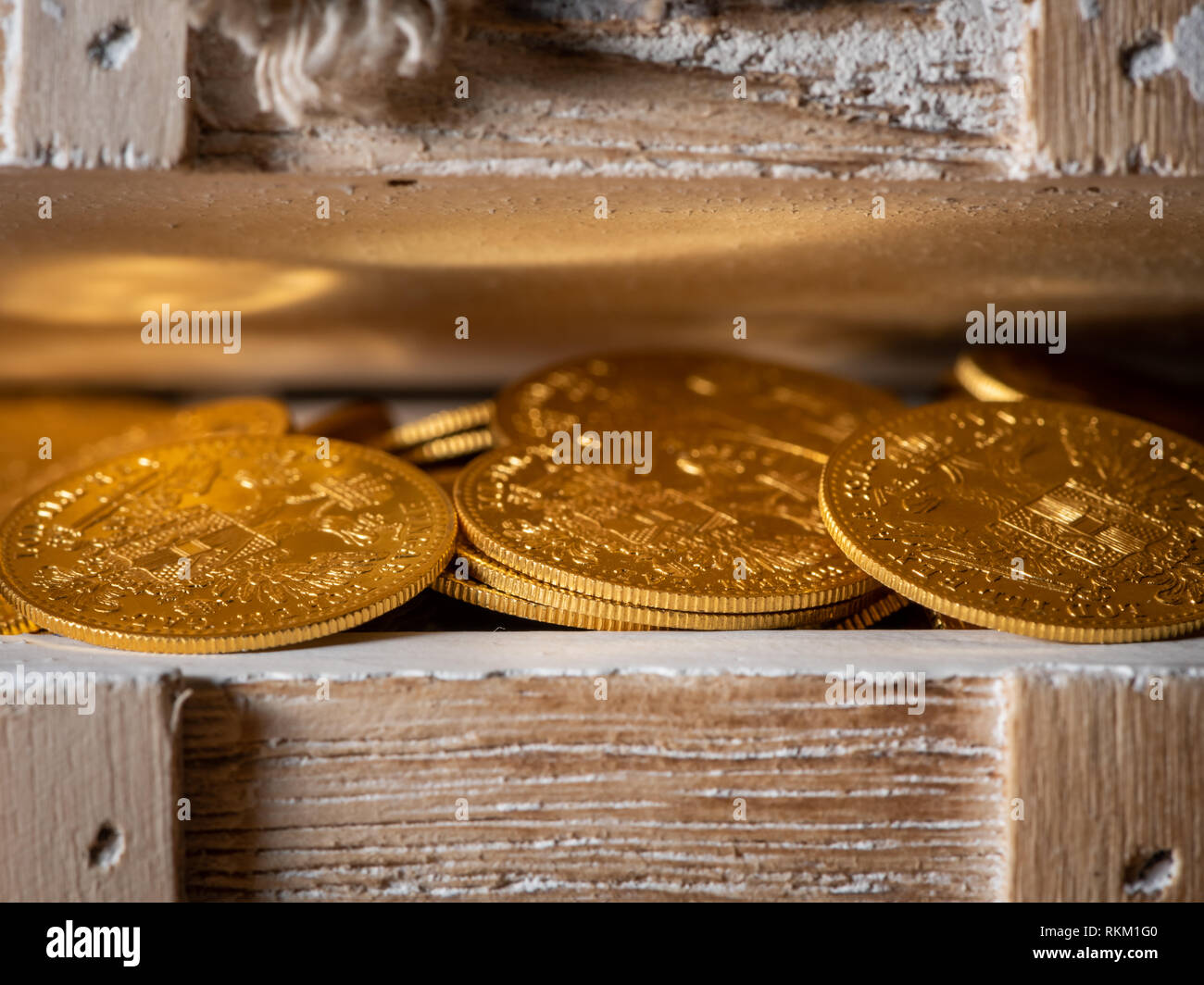 Shiny gold coins (Austrian ducats) in a small wooden treasure box Stock Photo