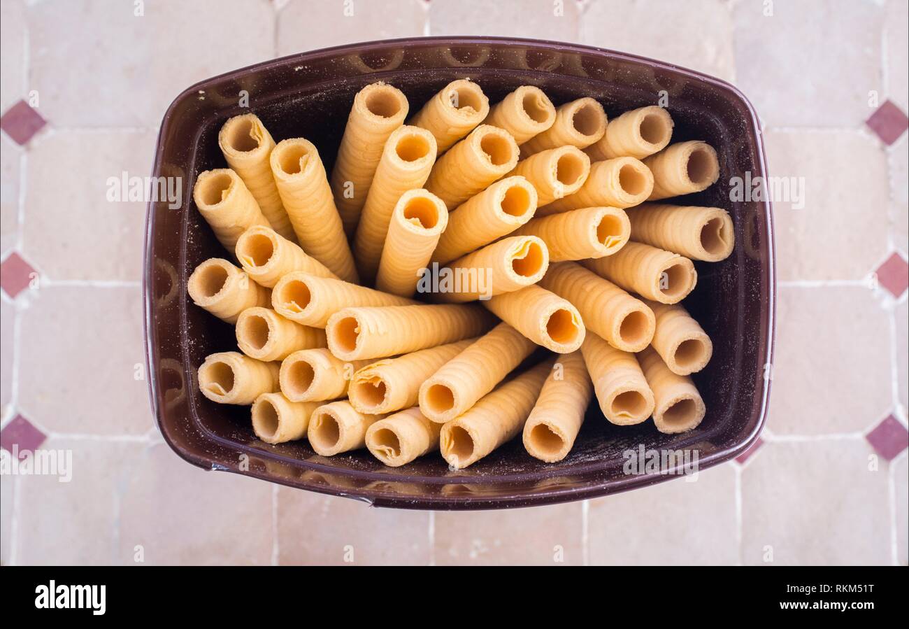 Biscuit rolls on open package. Mosaic glazed tile background. Stock Photo