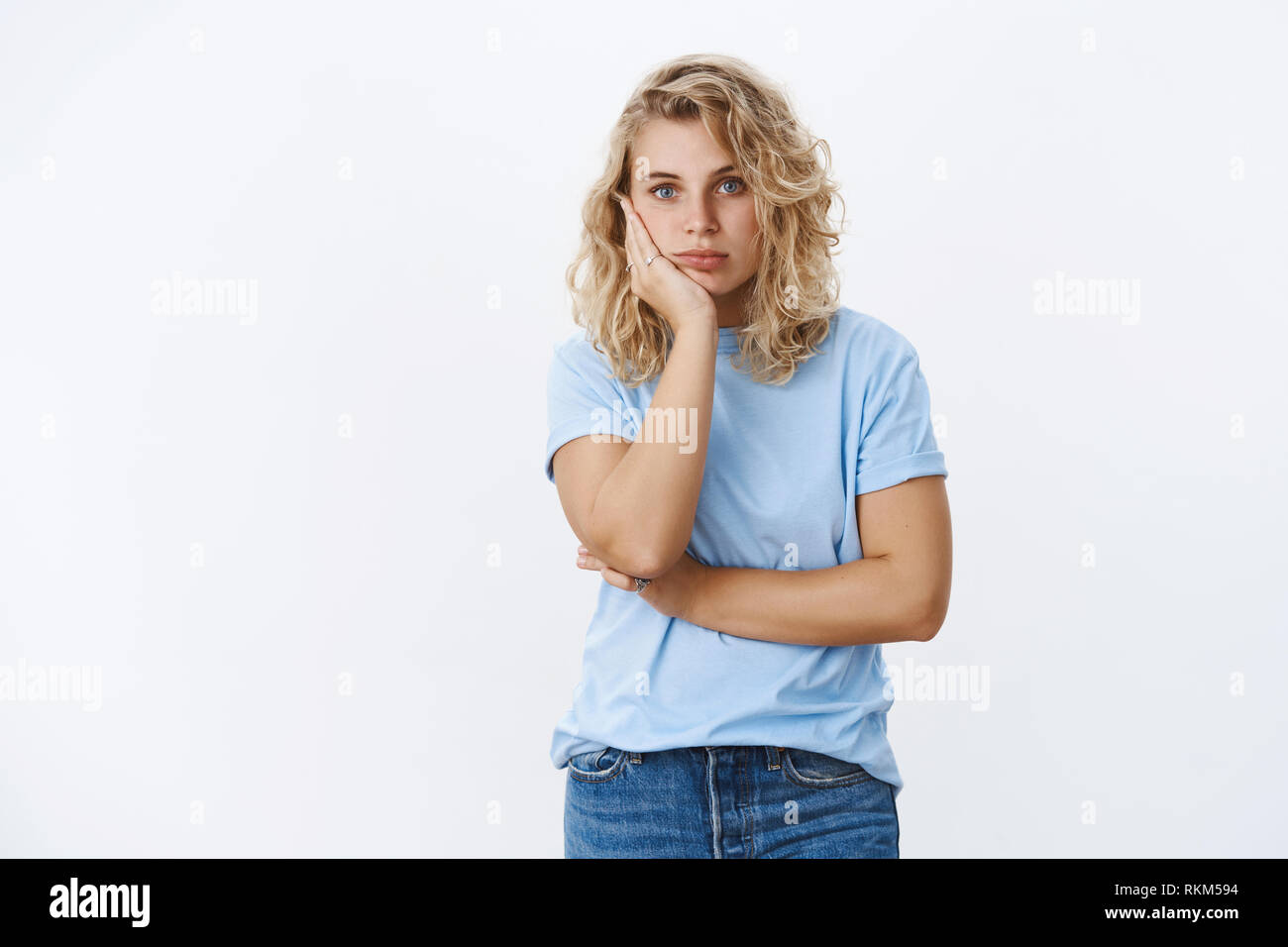 Oh my god distaster. Portrait of shocked girl in stupor leaning on palm and staring speechless at camera as being impressed and stunned with shook Stock Photo
