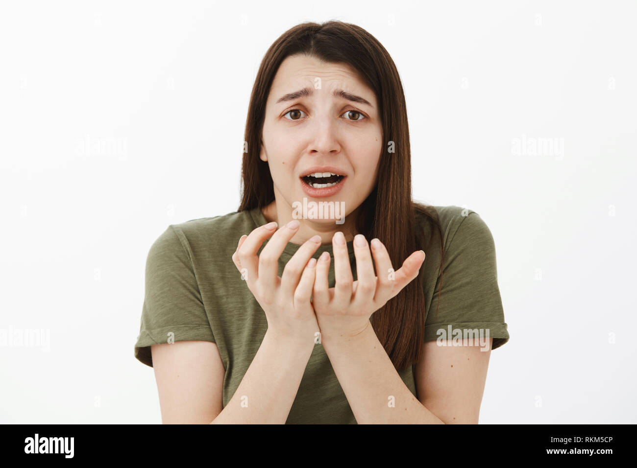 Woman in despair having problems standing freaked out in panic, distressed and upset losing everything holding shaking hands nead face frowning and Stock Photo