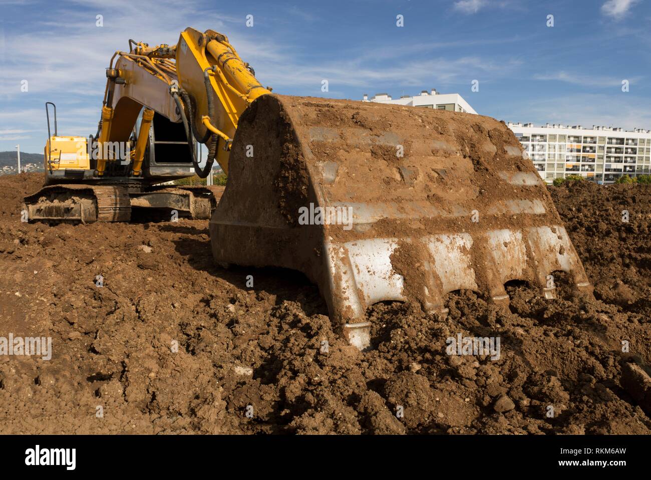 Earthmoving excavator preparing the construction site soil. Scoop detail. Stock Photo