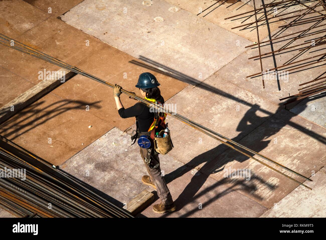 Construction worker carries steel bars at Vancouver House, a tower