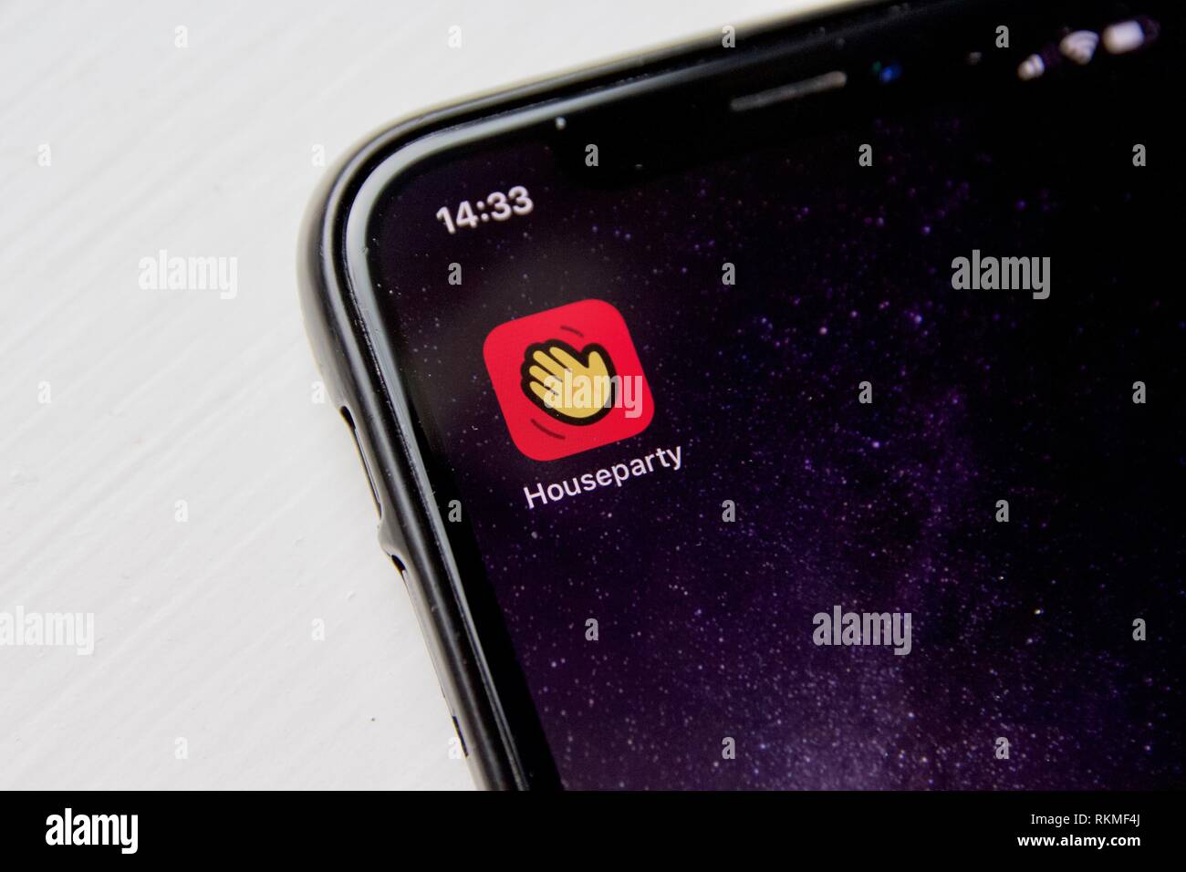 The app Houseparty on an iPhone X against a white background. Houseparty is a group video app aimed at tweens Stock Photo