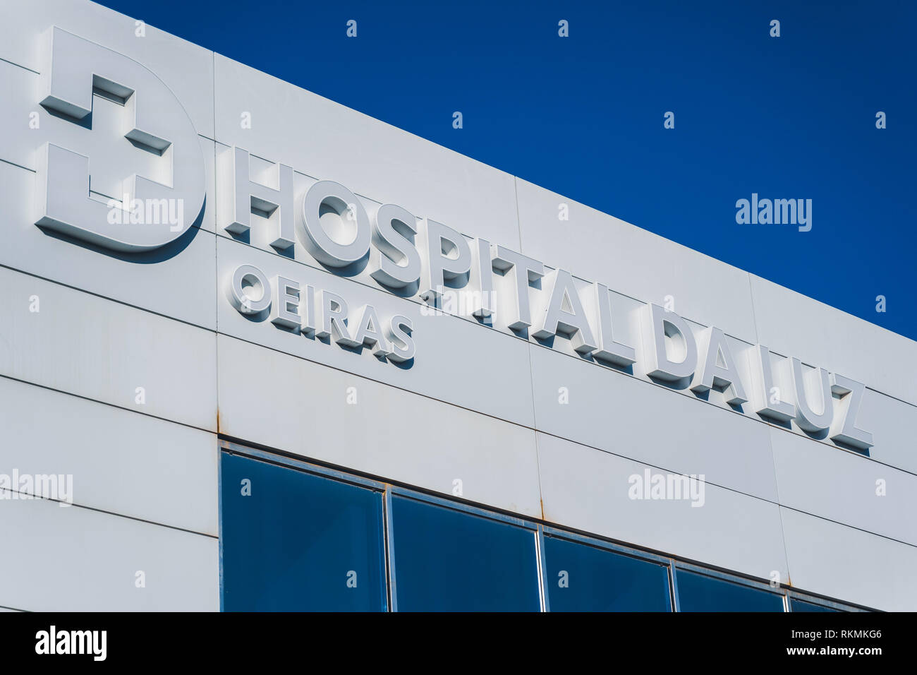 Oeiras, Portugal - 01/05/19: Hospital da Luz (of Light), Oeiras. Big sign with the logo of the private hospital. Emergency and general entrance. Blue  Stock Photo