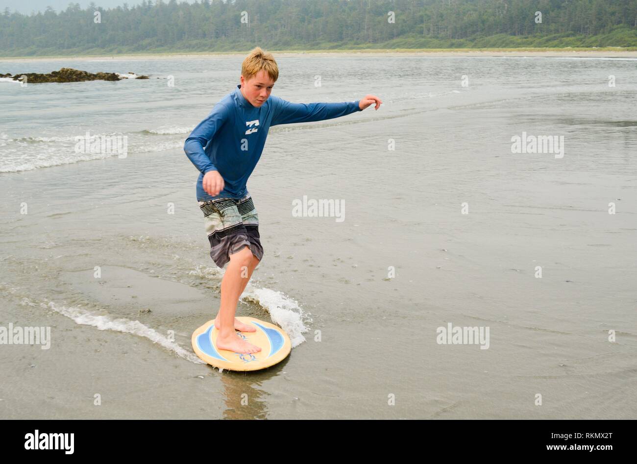 Teenage boy skim boarding on Flores Island, off the west coast of