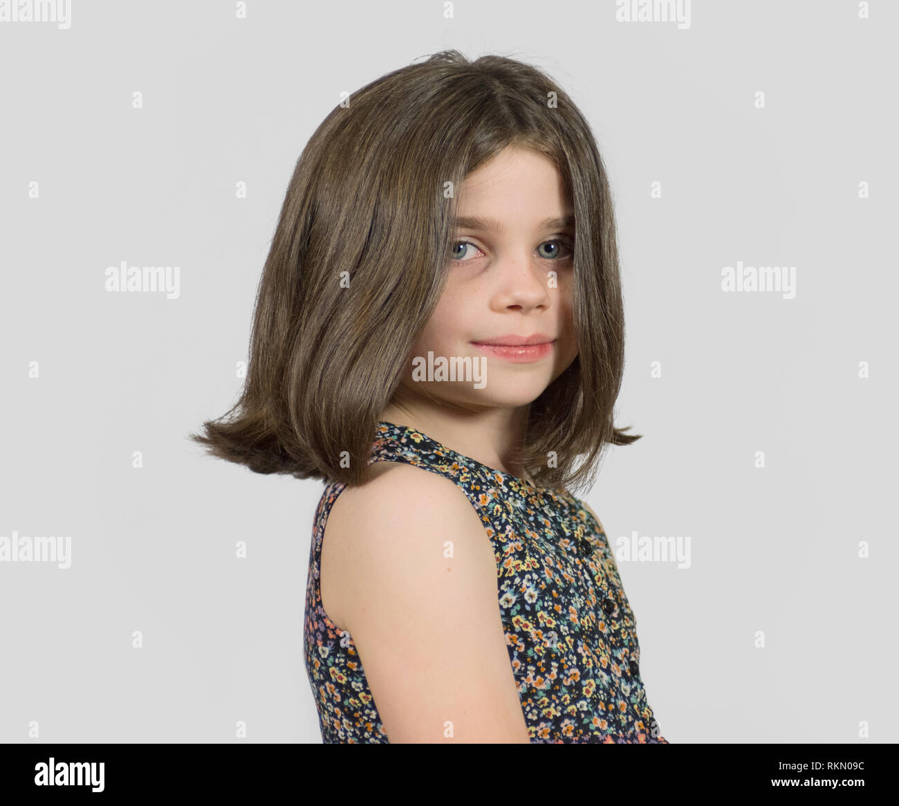 Headshot of smiling little girl with short bob hair cut Stock
