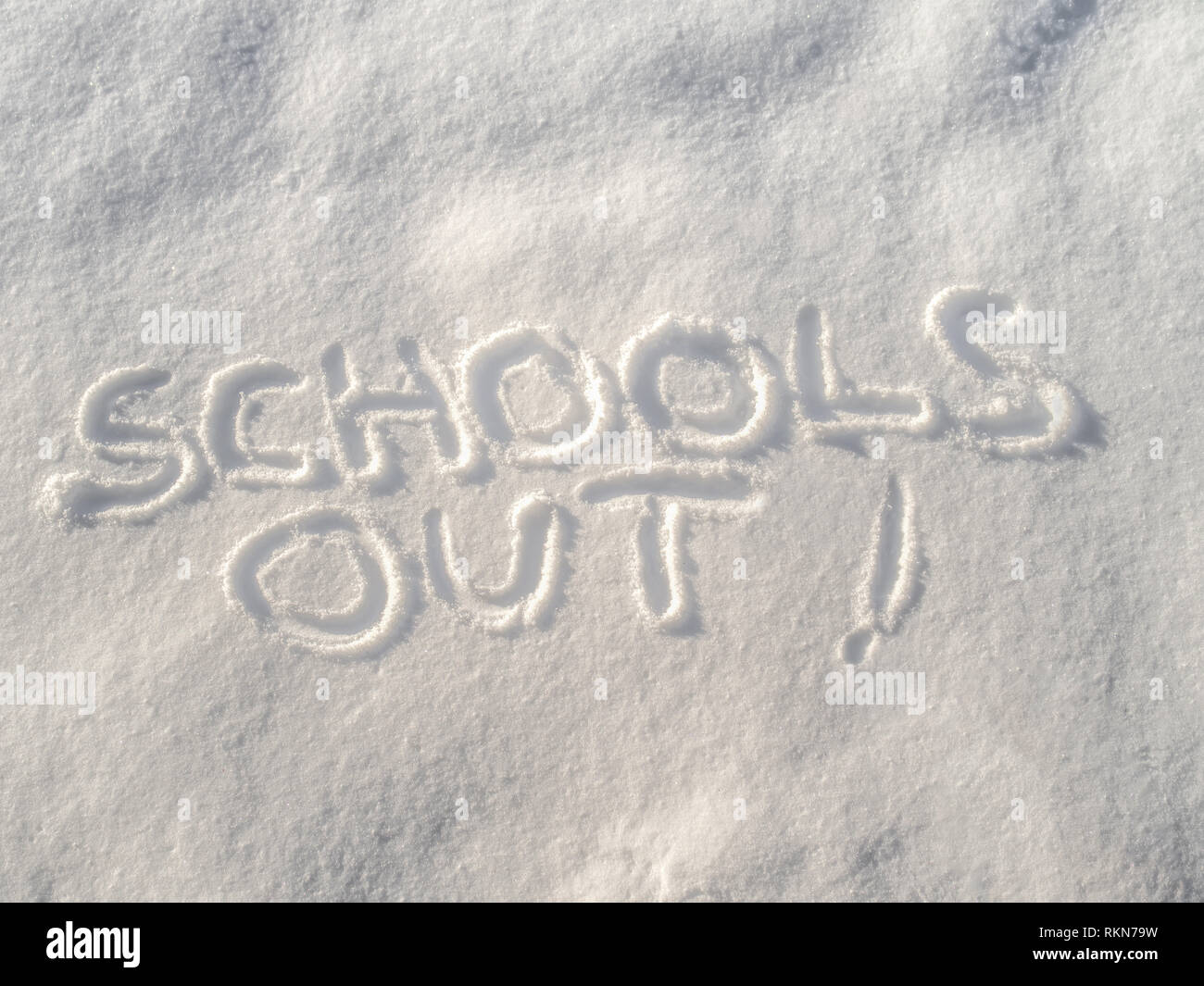 Words 'Schools out!' written in fresh fallen snow with copy space concept. Stock Photo