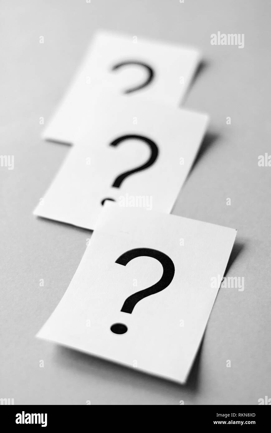 Questions Mark Queue White cards with printed question marks on grey background with copy ...