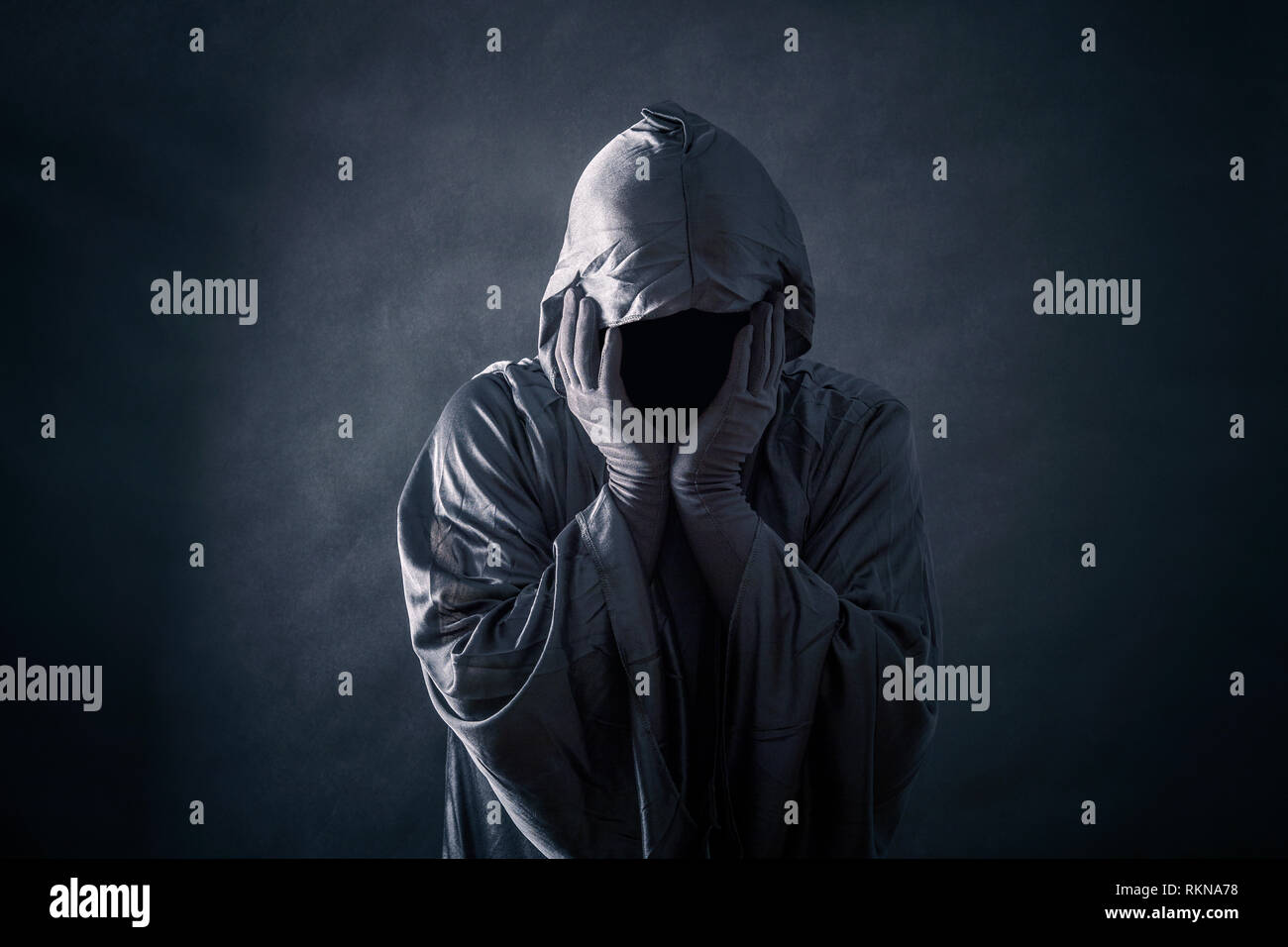Scary figure in hooded cloak Stock Photo