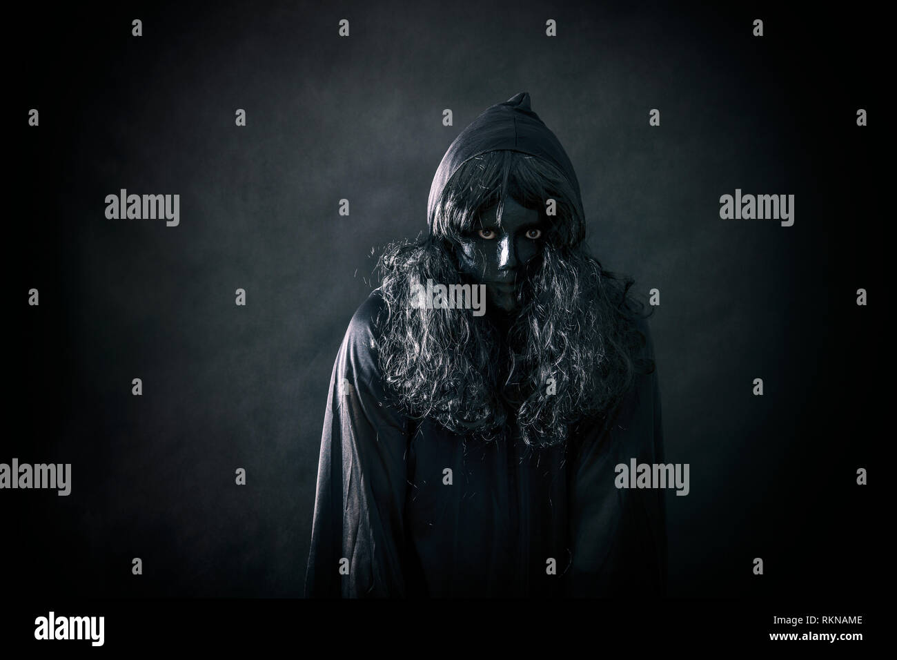 The witch in hooded cloak Stock Photo