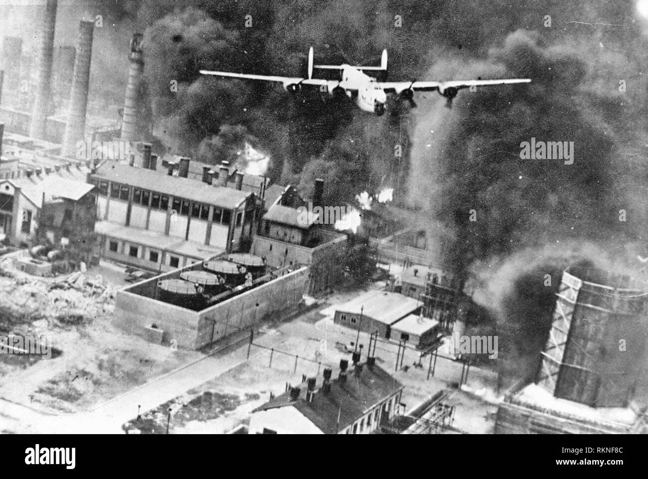 Air Raid Ploesti. A B-24 flying over a burning oil refinery at Ploesti, Rumania, 1 August 1943. Stock Photo