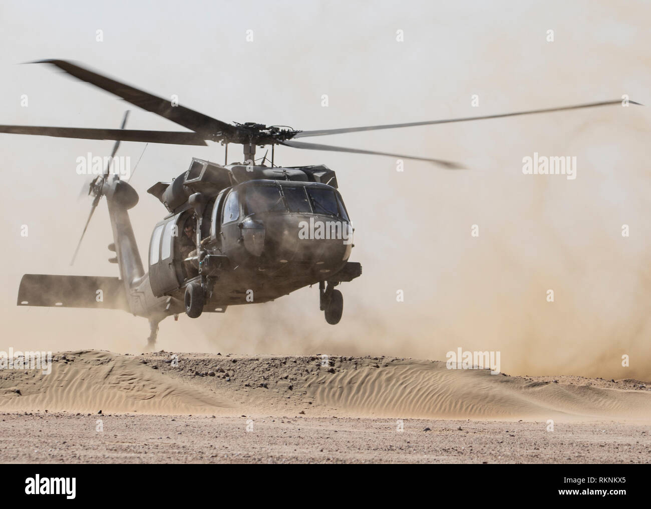 Flight crews from the Kansas National Guard’s 1st Battalion, 108th Assault Helicopter Battalion, provide lift capability for aerial sniper training at Camp Beuhring, Kuwait, on Jan. 29, 2019. The UH-60 Black Hawk Helicopters challenged the snipers on their aerial platform by moving through the air at various speeds and altitudes to familiarize themselves with the effects of bullet drop. Utilizing verbal and non-verbal communication techniques, the snipers from the Kansas National Guard’s Headquarters Company, 2nd Combined Arms Battalion 137th Infantry Regiment, 155th Armored Brigade Combat Tea Stock Photo