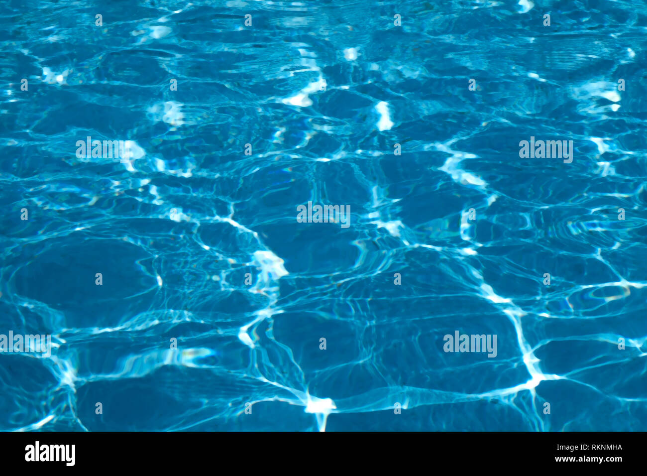 Blue and bright ripple clean water surface in swimming pool with sun ...