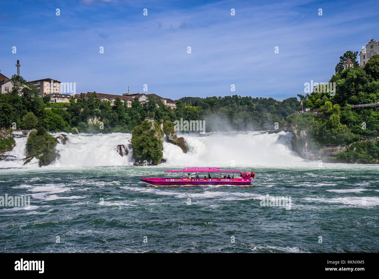 a tour boat is nearing the Rhine Falls (Rheinfall), against the backdrop of the cliff-top castle of Schloss Laufen, cantons of Zürich and Schaffhausen Stock Photo