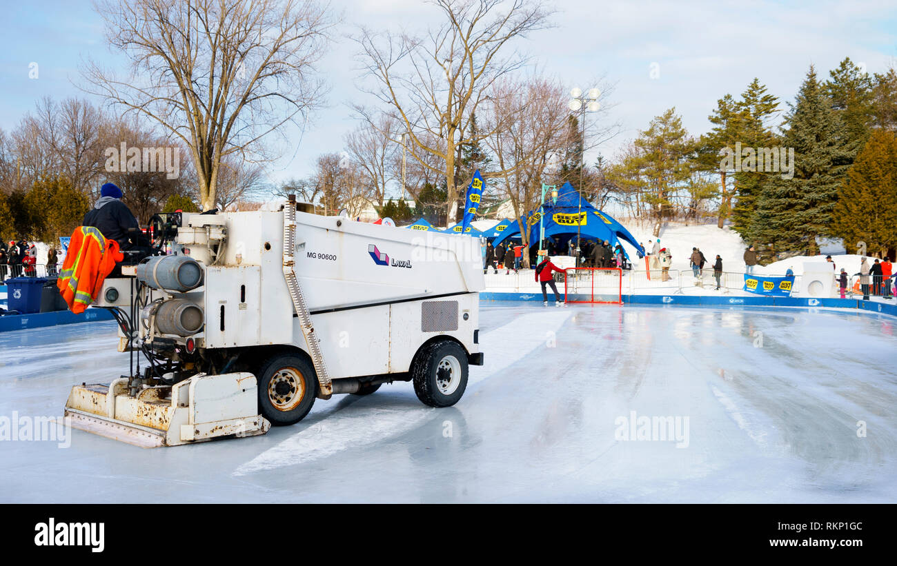 Zamboni resurfacing machine cleaning the ice on an outdoor skating rink. Stock Photo