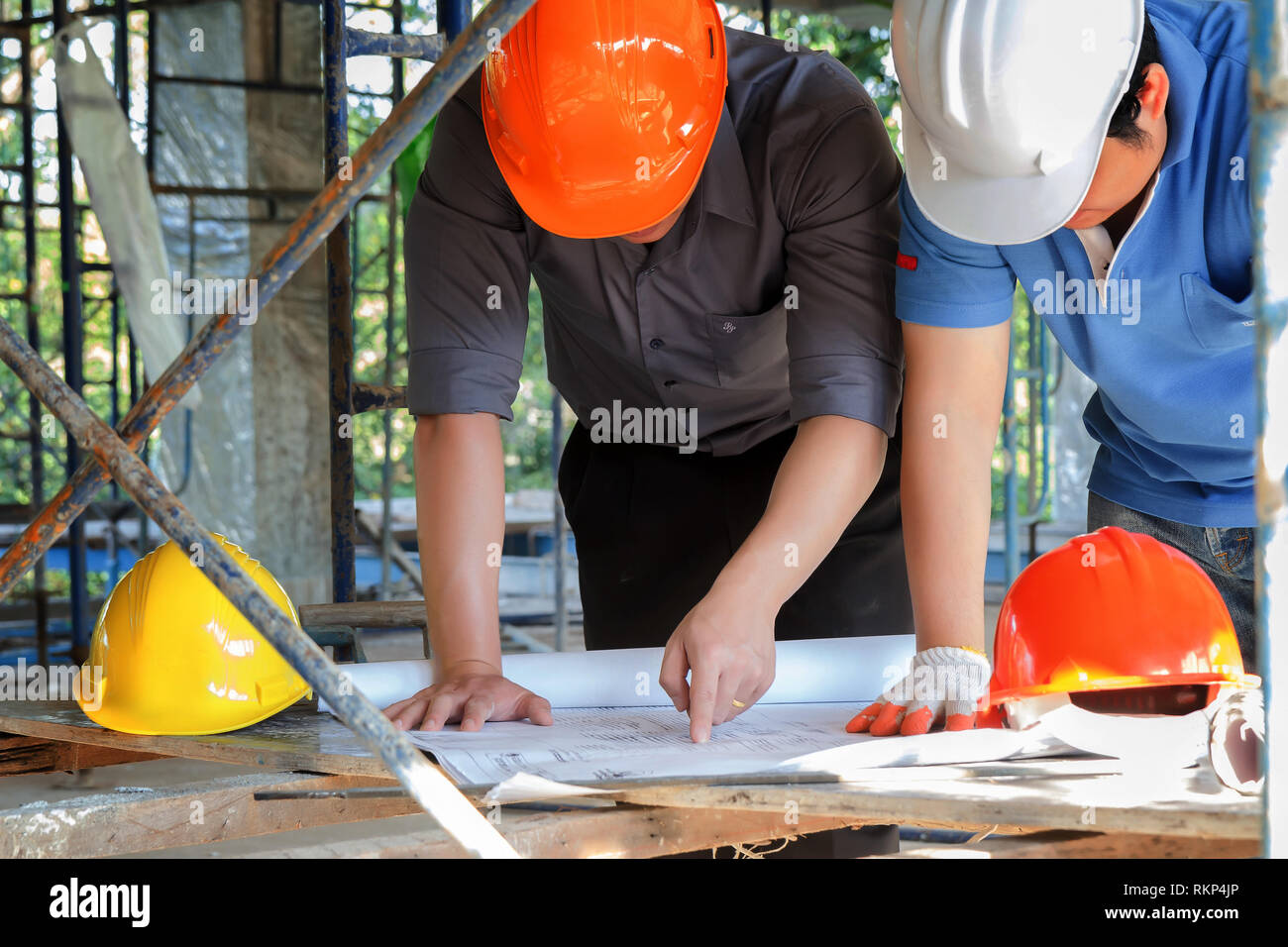 Engineer discussing with foreman about project in building construction site Stock Photo
