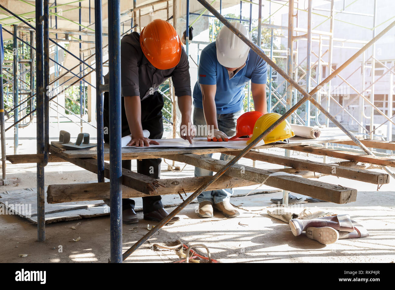Engineer discussing with foreman about project in building construction site Stock Photo