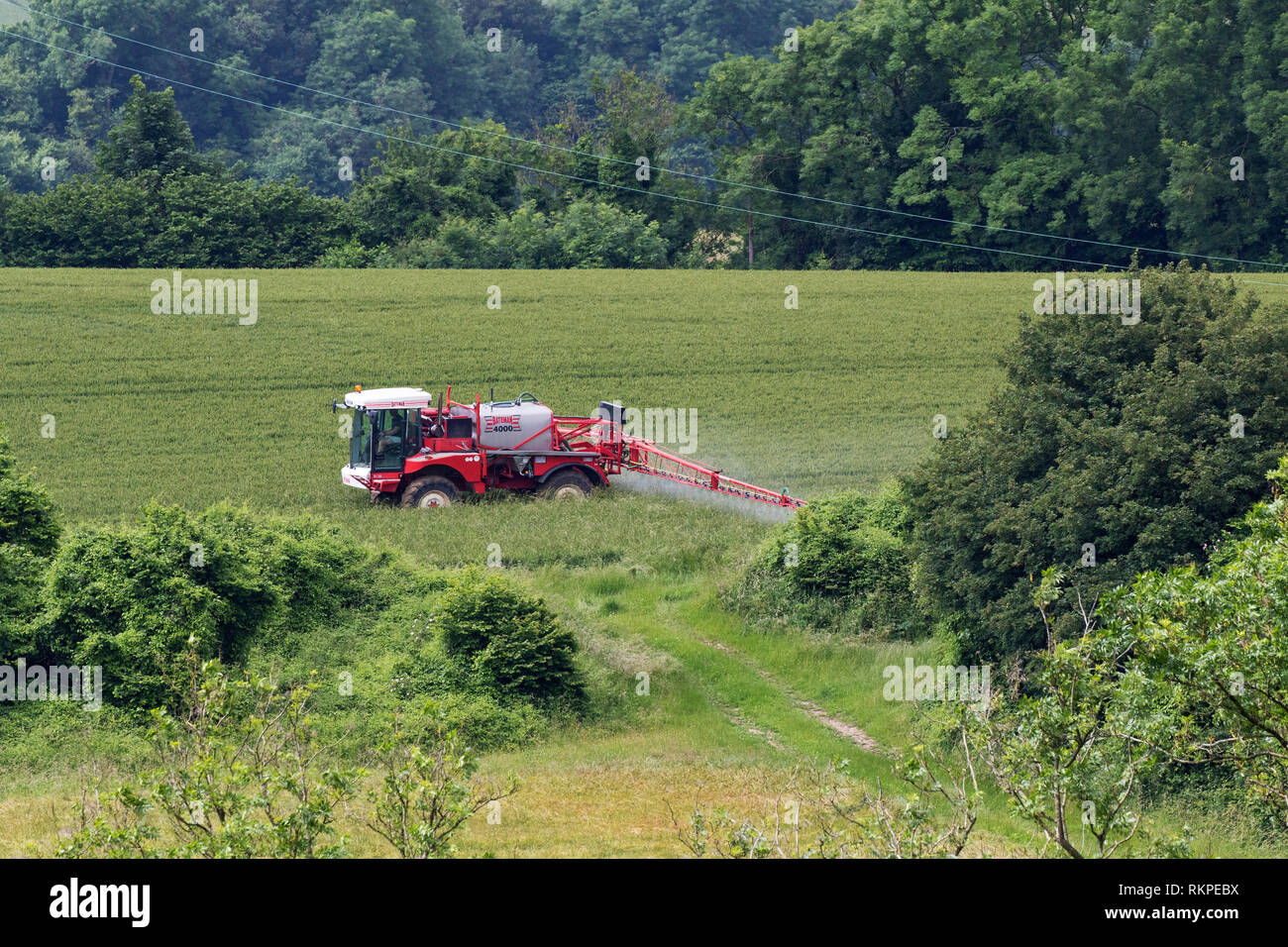Crop spraying beside Noar Hill Hampshire and Isle of Wight Wildlife Trust Reserve near Newton Valence Hampshire England UK June 2016 Stock Photo