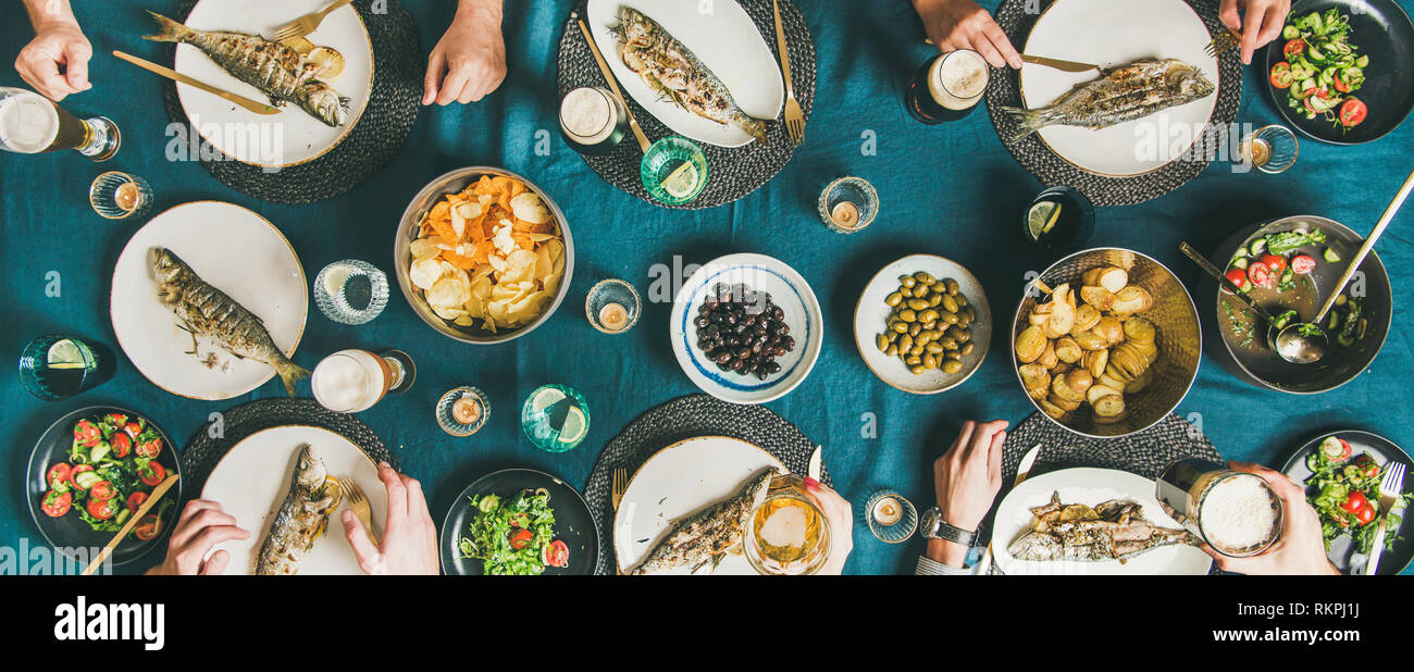Friends eating fish and chips and drinking beer, wide composition Stock