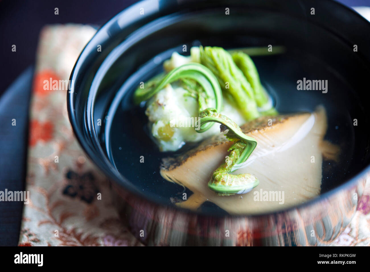 Soup of simmered abalone and scallop dumpling with fragrance of 'Fukinoto'. Tenku Ryu-Gin is the fine dining kaiseki restaurant of Seiji Yamamoto in H Stock Photo