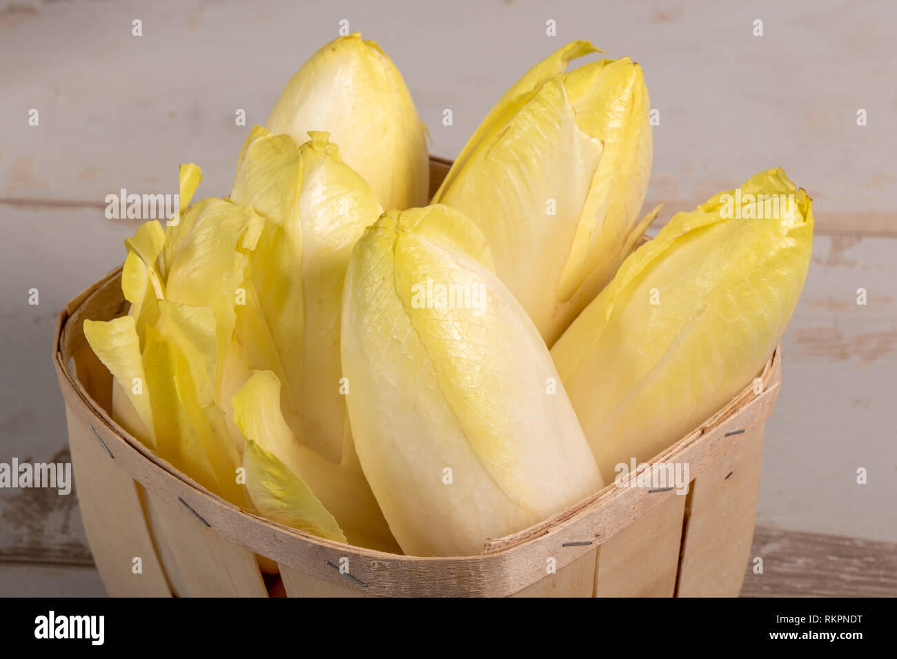 delicious chicory endives from France or Belgium in a small wooden basket Stock Photo