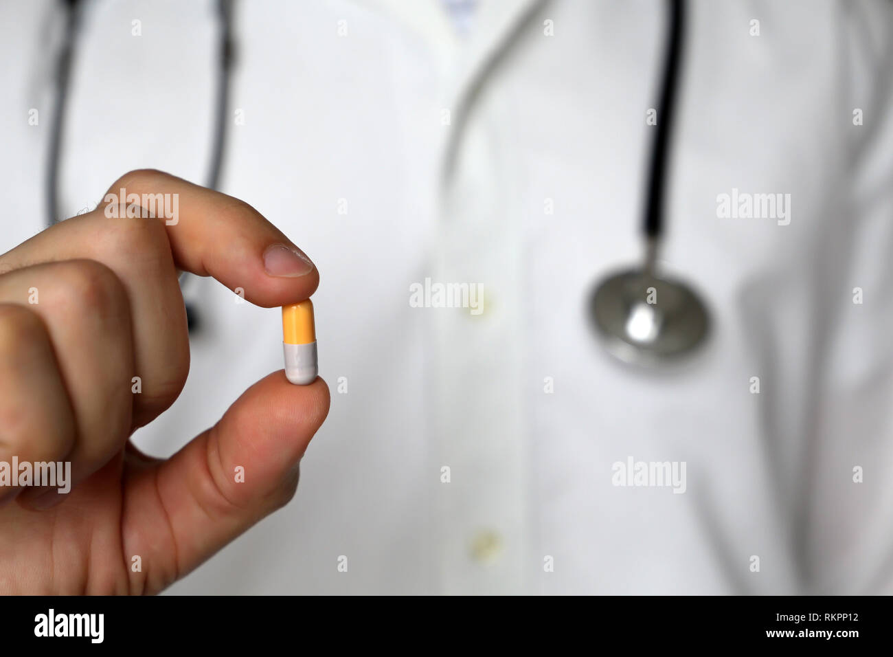 Doctor with pill, man with stethoscope holding capsule. Concept of medications, vitamins, prescription, medical exam, pharmacist Stock Photo