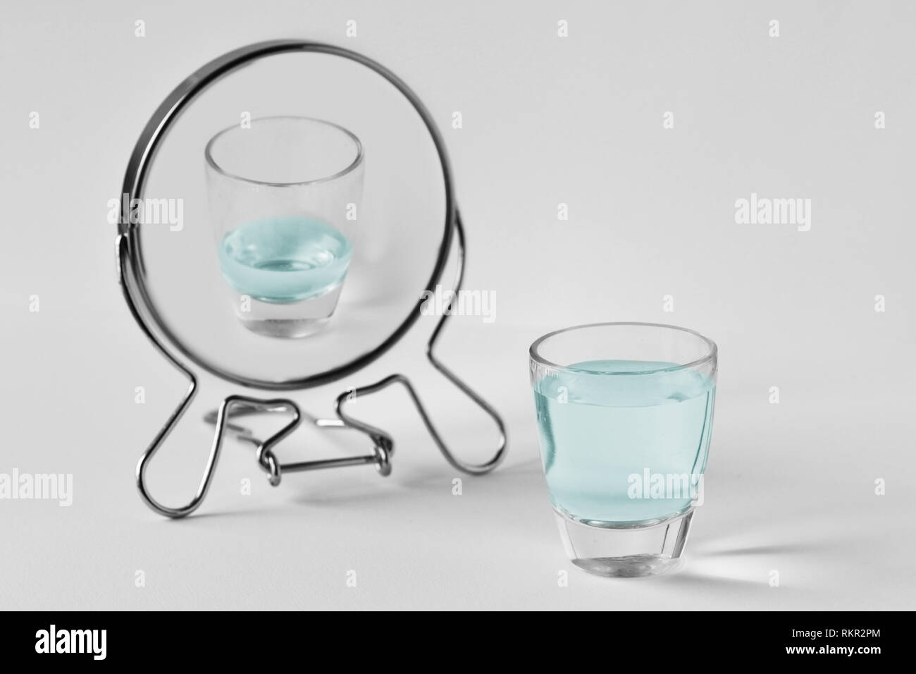 Full water glass looking in the mirror and seeing himself as an empty glass - Concept of pessimism Stock Photo