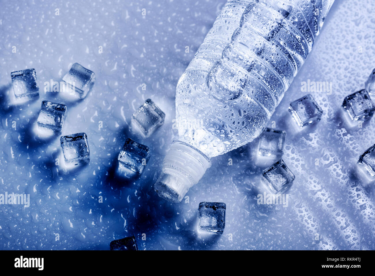 Fresh drinking mineral water in plastic bottle with ice cubes and iced drops. Healthy living concept from above. Stock Photo