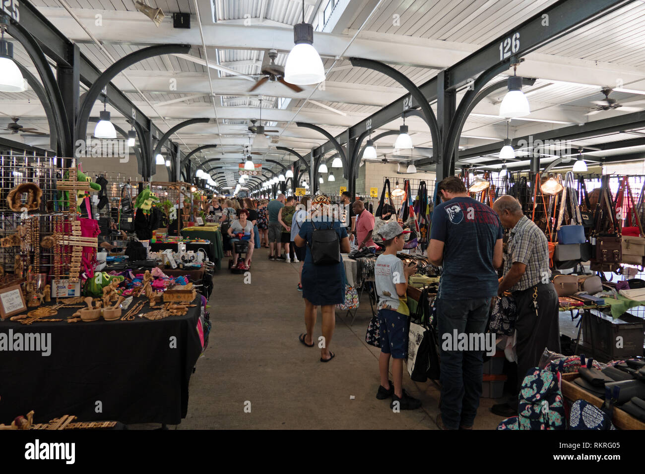 People and tourists shopping for souvenirs at the flea market inside the French Market in the French Quarter of New Orleans, Louisiana, United States  Stock Photo