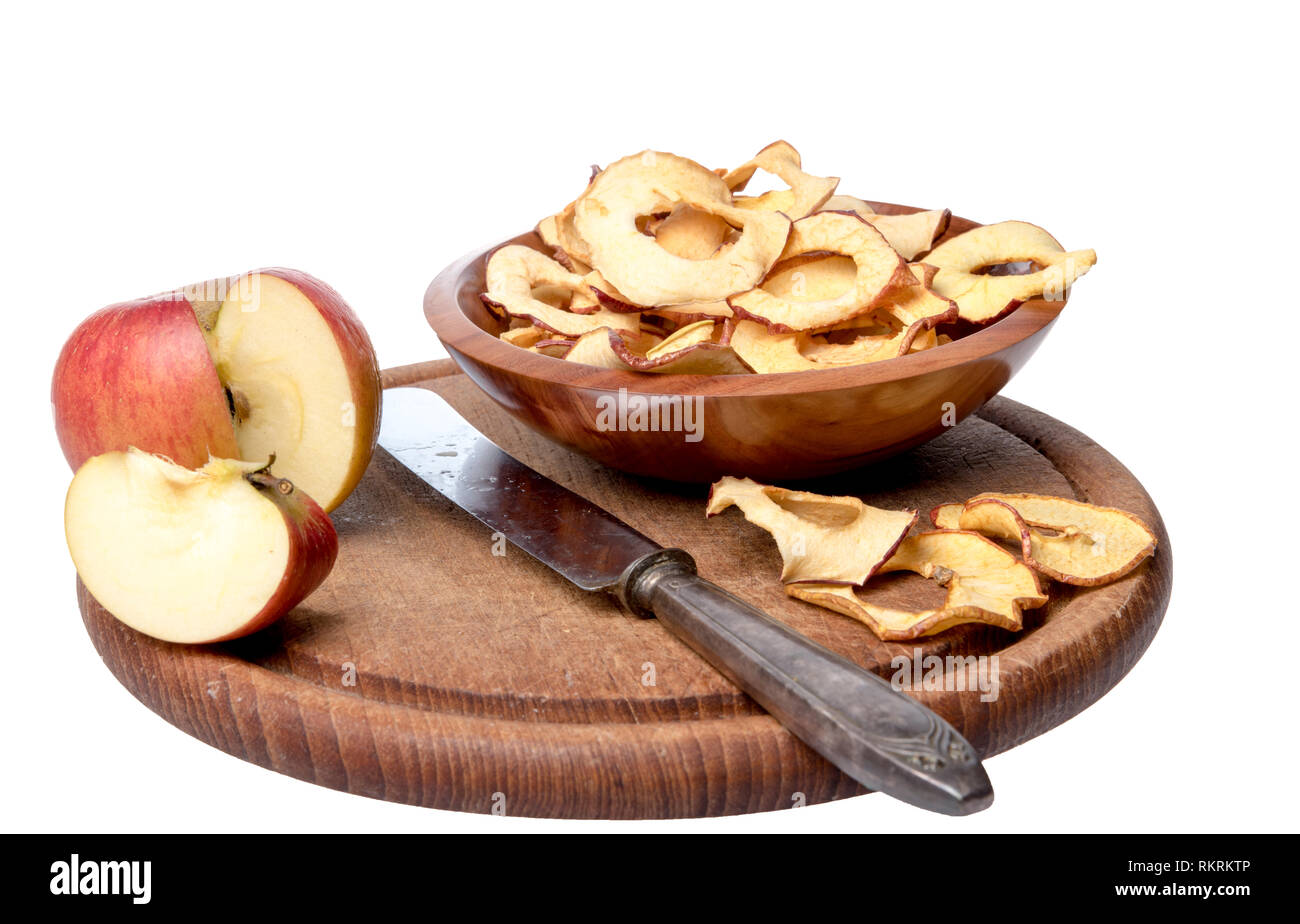 Dried apple rings lie on a board with a freshly cut apple Stock Photo